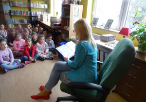Dzieci słuchają bajki czytanej przez panią Małgorzatę Hofamnn.